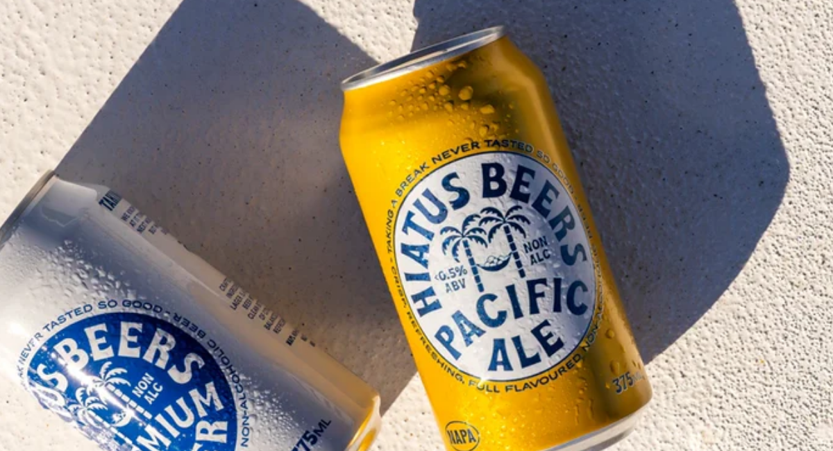Two chilled non alcoholic beer cans, including Pacific Ale and Another Lager, photographed in sunlight.